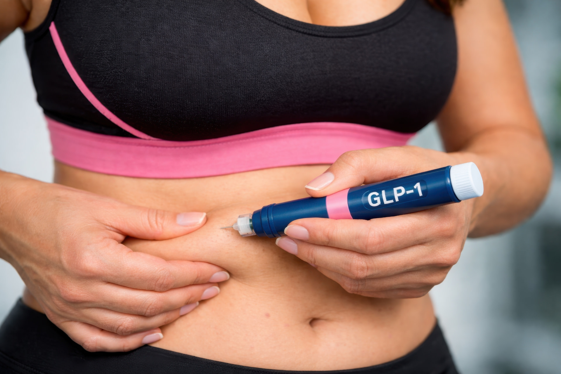Woman administering a once-weekly GLP-1 injection in her abdomen